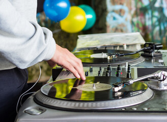 DJ playing music at a hip hop party. analog turntable, Dj uses turntable and mixer for scratching.