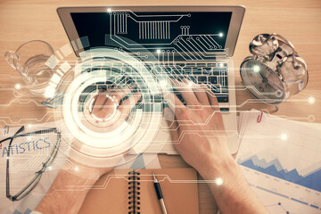 Double exposure of man's hands typing over computer keyboard and data theme hologram drawing. Top view. Technology concept.