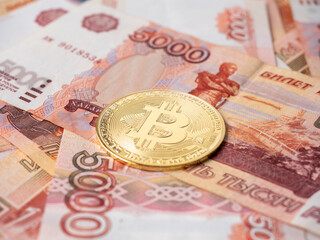 the bitcoin coin lies on the background of Russian rubles. Cryptocurrency mining and Mining Concept. Side view