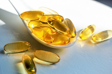 spoon with capsules of fish oil omega 3 fatty acids close-up