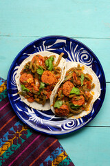 Mexican food. Chorizo and nopales tacos on turquoise background