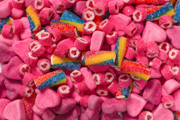 Assorted tasty gummy candies. Pink jelly sweets background.