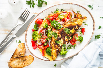Omelet with fresh vegetables - broccoli, tomatoes and paprika. Healthy breakfast. Top view image.