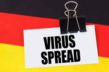 On the flag of Germany lies a notebook with the inscription - VIRUS SPREAD