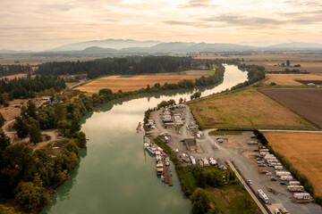 Aerial View of the Skagit River, Mt. Vernon, Washington. Drone shot of the Skagit River running through agricultural fields with the Cascade Mountains in the background.