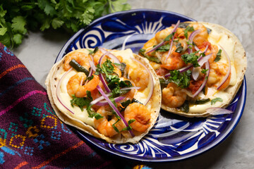 Mexican food. Shrimp tacos with melted cheese and poblano pepper called gobernador on grey background.