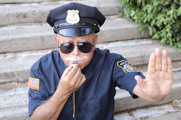 Senior American policeman showing stop hand sign 
