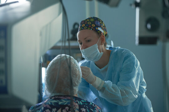 Ophthalmologist checking up eye of unrecognizable patient in clinic