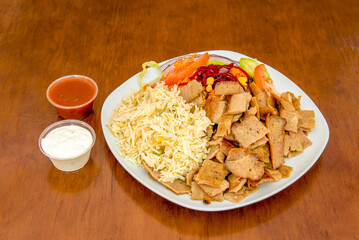 lamb kebab menu dish with basmati rice with sliced roast lamb meat with beets, carrots, cucumber and red onion with yogurt sauce and spicy tomato sauce