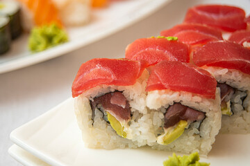 sushi uramaki california roll with red tuna, ripe avocado, cream cheese and nori seaweed with wasabi