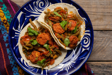 Mexican food. Chorizo and nopales tacos on wooden background