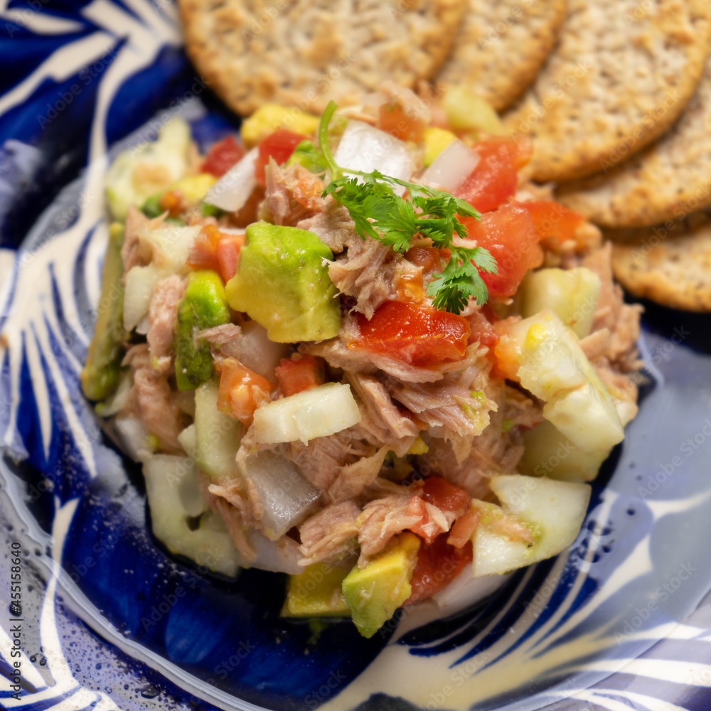 Wall mural Tuna salad with avocado and cucumber on grey background