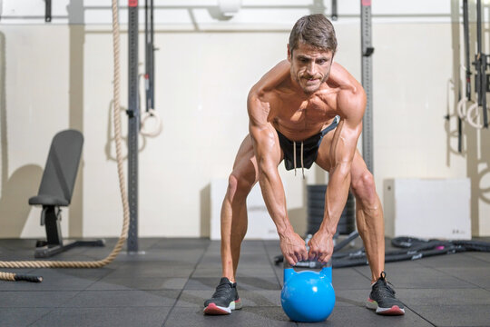 Young Fit man training with kettlebells. High quality photo