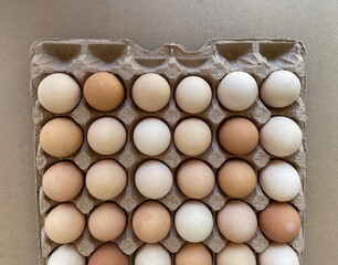 Overhead view of free-range organic chicken brown eggs in tray. Background with chicken eggs. Eggs for Easter. Background for cafes, restaurants, fast food outlet. Craft background.