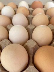 Overhead view of free-range organic chicken brown eggs in tray. Background with chicken eggs. Eggs for Easter. Background for cafes, restaurants, fast food outlet. Craft background.