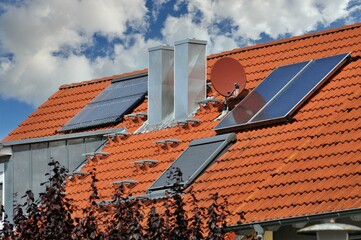 Technische Anlagen auf einem Wohngebäude: Satelliten-Antenne, Edelstahl-Schornstein mit...