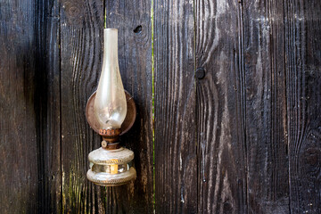 Old kerosene lamp hang on nail on wooden wall