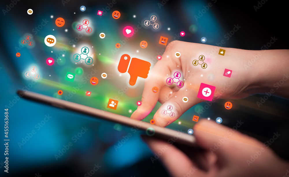 Poster close-up of a hand using tablet with social media icons