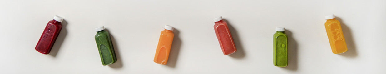 Flat-lay of fresh natural organic juices in bottles, wide composition