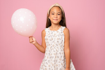 Beautiful little girl with pastel pink air balloon with okay sign isolated over pink background.