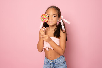 Happy smiling girl with sugar lollipop. Little girl portrait with big candy. Sugar for kids.