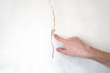 Construction man worker repairing a crack wall of a home, plastering cement on wall. Builder...