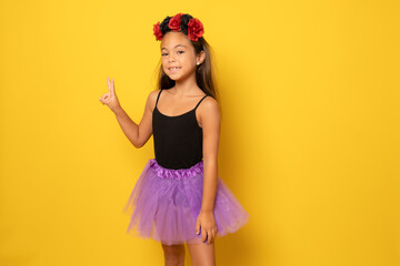 Beautiful little girl in Halloween costume isolated over yellow background.Halloween, carnival,...