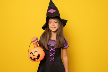 Beautiful little girl in Halloween costume isolated over yellow background.Halloween, carnival, childhood, fairytale theme.