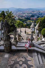 A woman sitting on the stairs of Bom Jesus do Monte church near the city of Braga, Portugal.