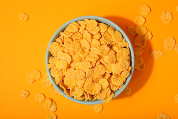 Delicious cornflakes in a plate against colored background. 