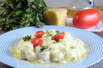 pasta in white sauce with parmesan cheese, tomato, basil, herbs, delicious food from Italian and French cuisine