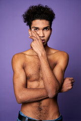 Fototapeta premium Transgender model posing. Portrait of young man without t-shirt isolated on purple background