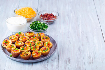 Baked mini red skinned loaded potatoes with crispy bacon, scallions and sharp cheddar cheese