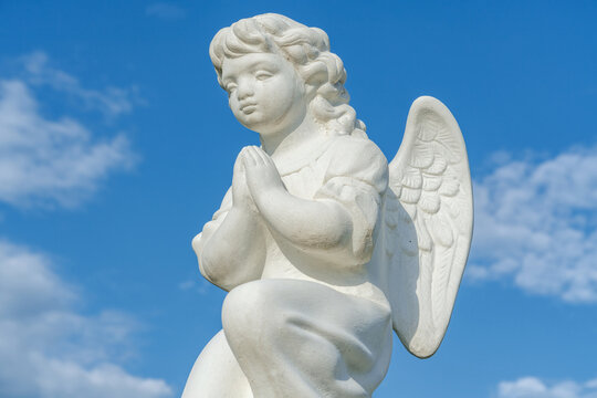 Stone angel on a sky background (religion, faith concept)
