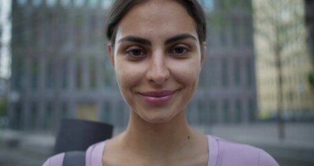 Physical activity and wellbeing concept. Glad smiling woman restores strength after training glad to have yoga practice with instructor outdoors enjoys good day poses in urban setting does sport