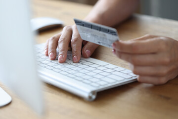 Woman paying online with plastic credit card closeup