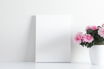 White canvas mockup and vase with pink flowers on white table