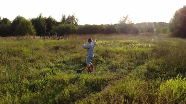 funny guy is dancing in field in the middle of nowhere. man in shirt and blue shorts with long red socks and headphones dance strange fun dance, camera is circling spin around him.