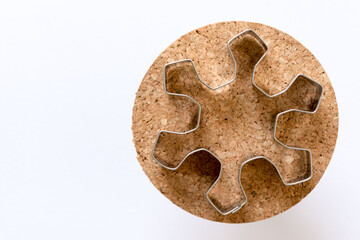 isolated Christmas cookie cutter in the shape of a snowflake (or star) on cork and white space