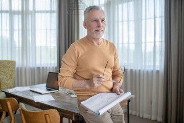 A picture of a man with project papers in hands