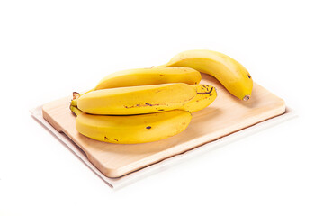 platano canario sobre tabla de cortar de madera y paño claro. aislada fondo blanco close-up