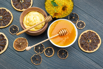 Obraz na płótnie Canvas Fresh flower honey of different varieties, pollen and honeycomb with spoons on a wooden background. Organic Vitamin Health Food