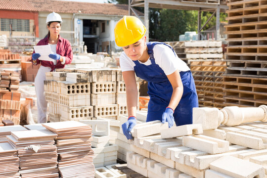 Attractive female sellerman is calculating redbricks before selling in construction store
