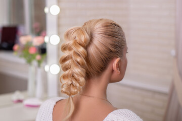 Female back with blonde braid hairstyle on hairdressing salon background - obrazy, fototapety, plakaty
