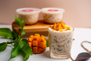 Mango Milk Cheese with a half of mango on white table with packaging for sale as background