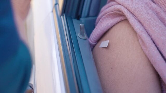 Covid Vaccine Being Injected In Shoulder Of Person In Car, Drive Through