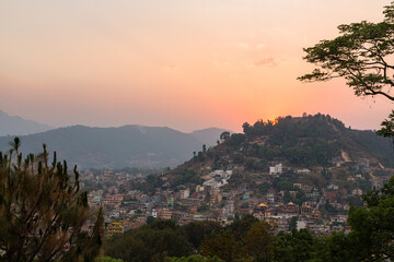 Fototapeta na wymiar ネパール　カトマンズのスワヤンブナート寺院のある丘から見えるカトマンズ盆地と夕焼けでオレンジに染まった空