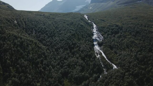 Beautiful white river through the green forest of Innerdalen, Norway -Aerial