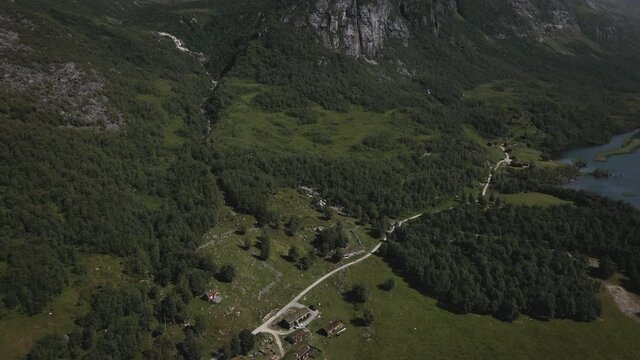 Lush Green Vegetation, Farmland, And Scenic Lake In Innerdalen, Norway - aerial drone shot