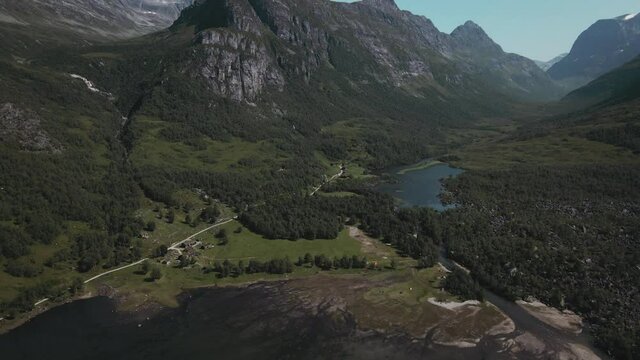 Majestic Mountains And Blue Lake In Innerdalen Norway - aerial pull out shot